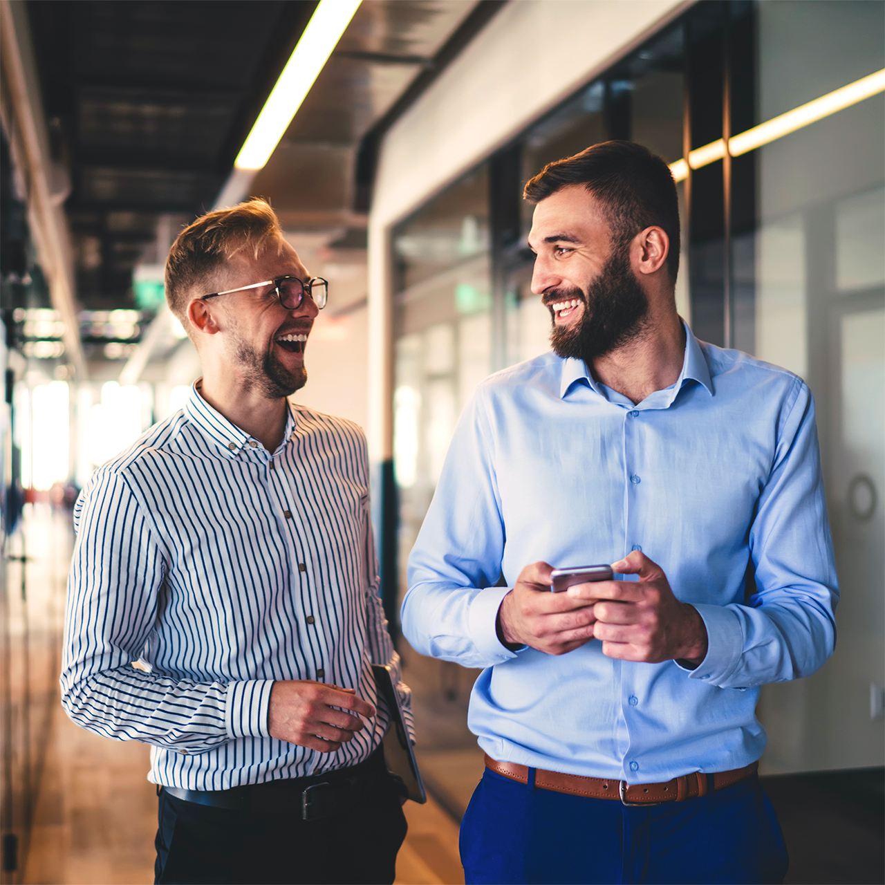 Cheerful male colleagues enjoying partnership in friendly workin WP Alt Text