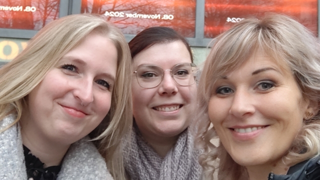 Drei Mitarbeiterinnen vor Kinoplakaten der starpool-Veranstaltung zur Veröffentlichung der neuen Marke.