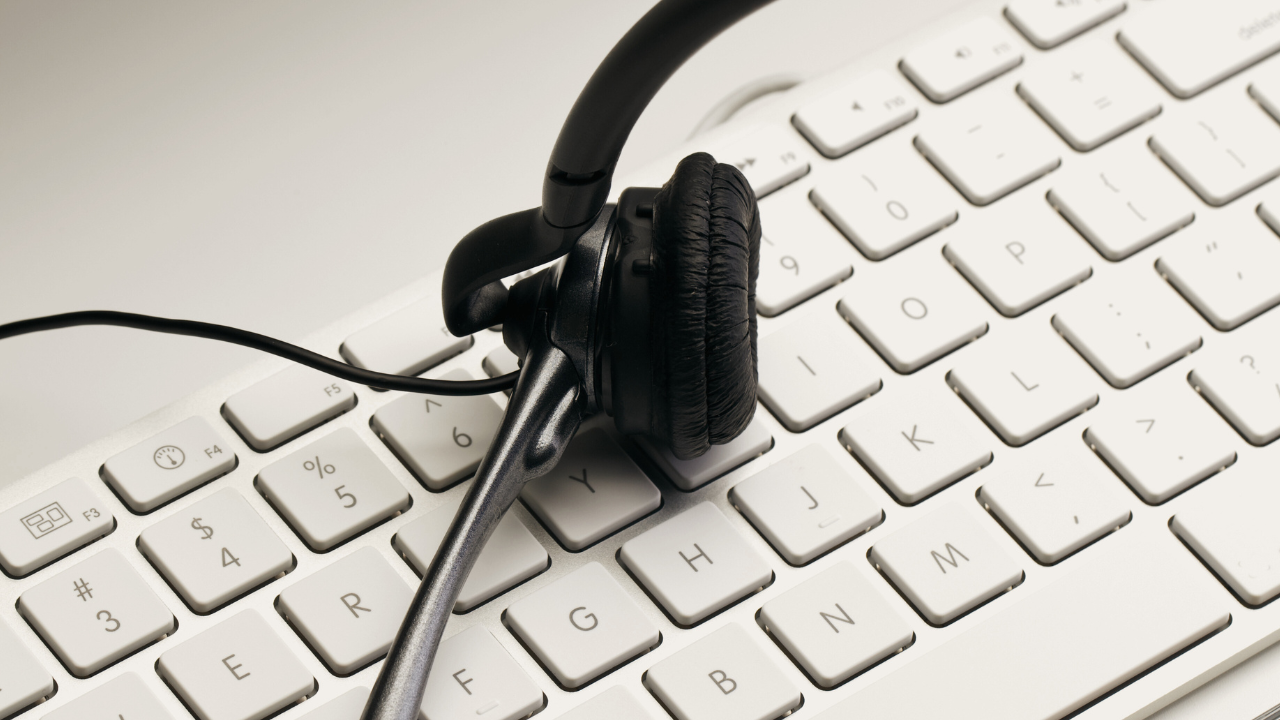 Headset auf einer Tastatur, Symboldbild für Service per Telefon