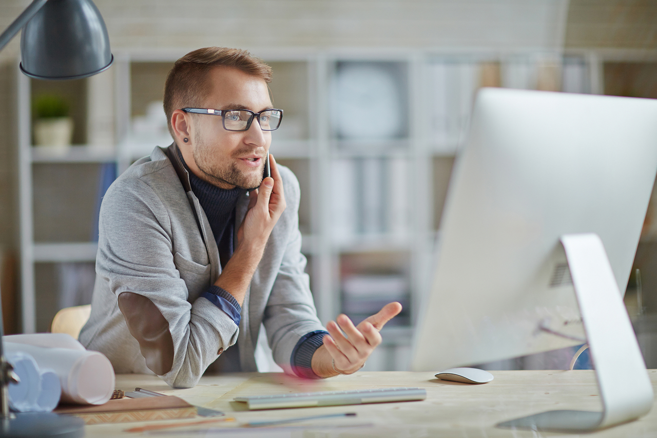 Vermittler arbeitet am Laptop, telefoniert